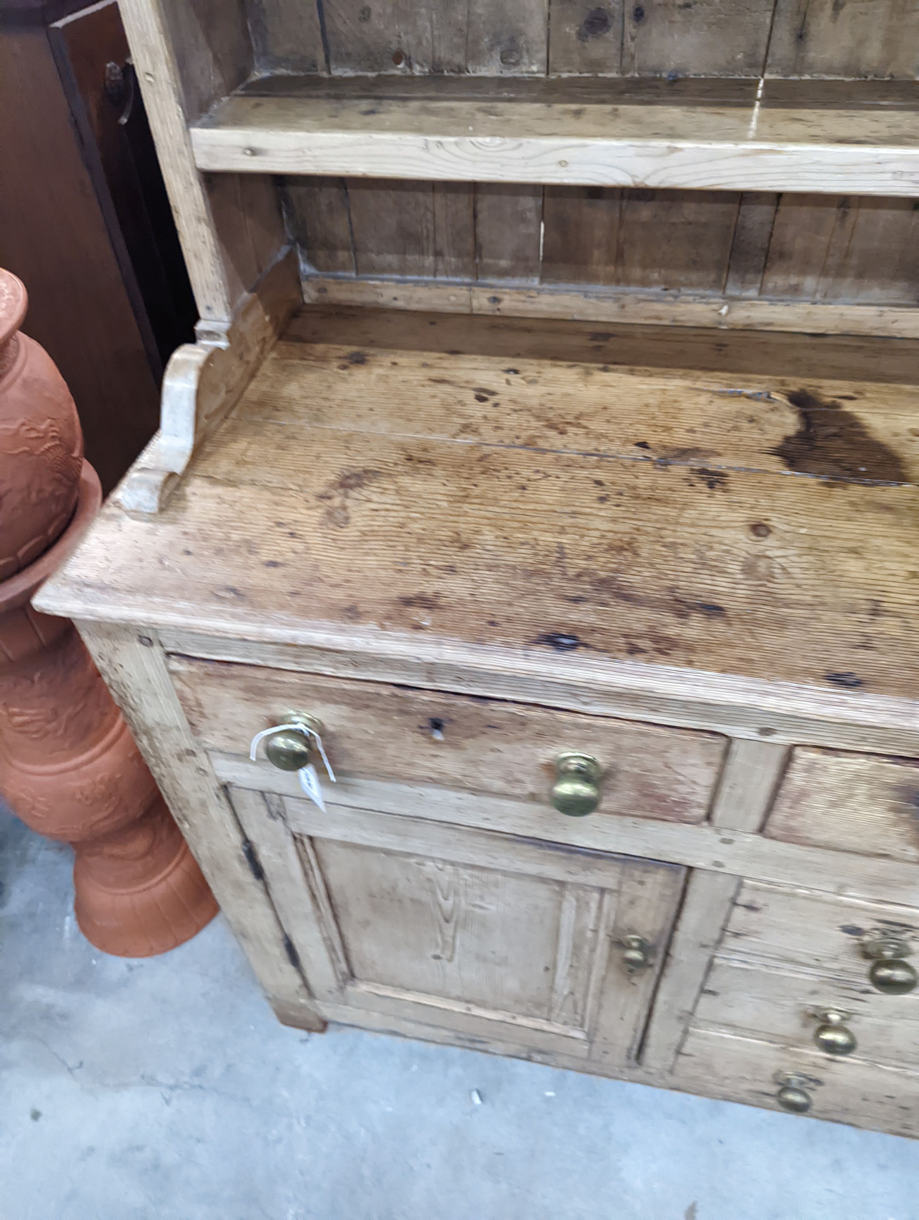 An early 19th century pine dresser with boarded rack, width 141cm, depth 49cm, height 206cm